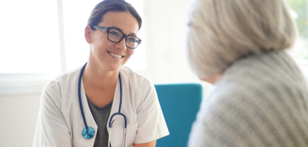 Young doctor comforting senior woman